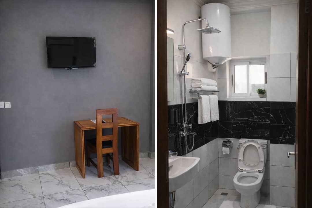 Chambre VIP du PADMA HOTEL à Douala avec télévision murale, bureau de travail et salle de bain moderne avec douche et eau chaude.